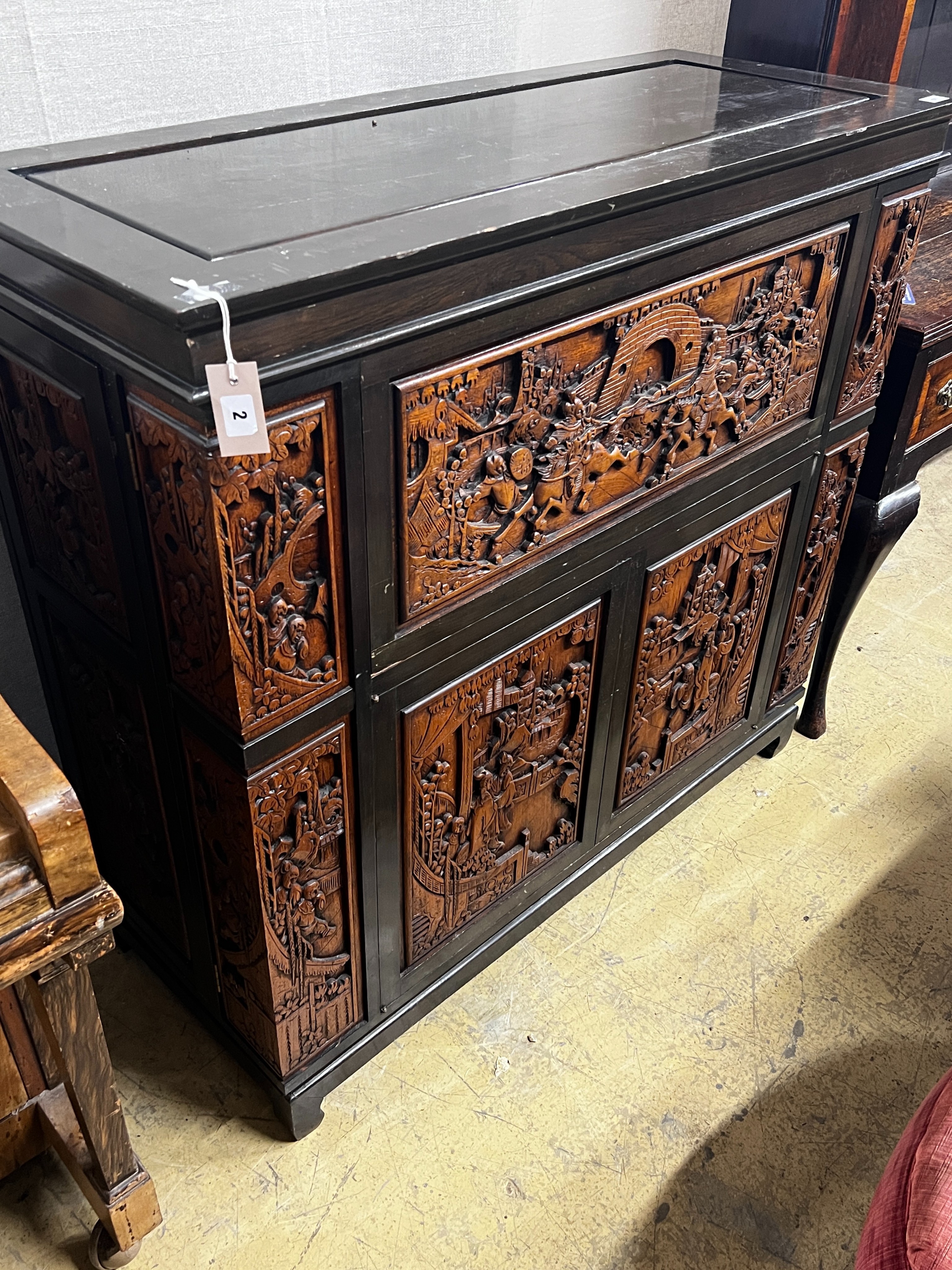 A Chinese carved hinged top cocktail cabinet with mirrored interior, width 111cm, depth 46cm, height 107cm